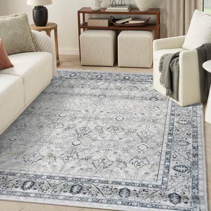 Blue-gray oriental area rug with floral medallions and border in a light living room with cream sofa.