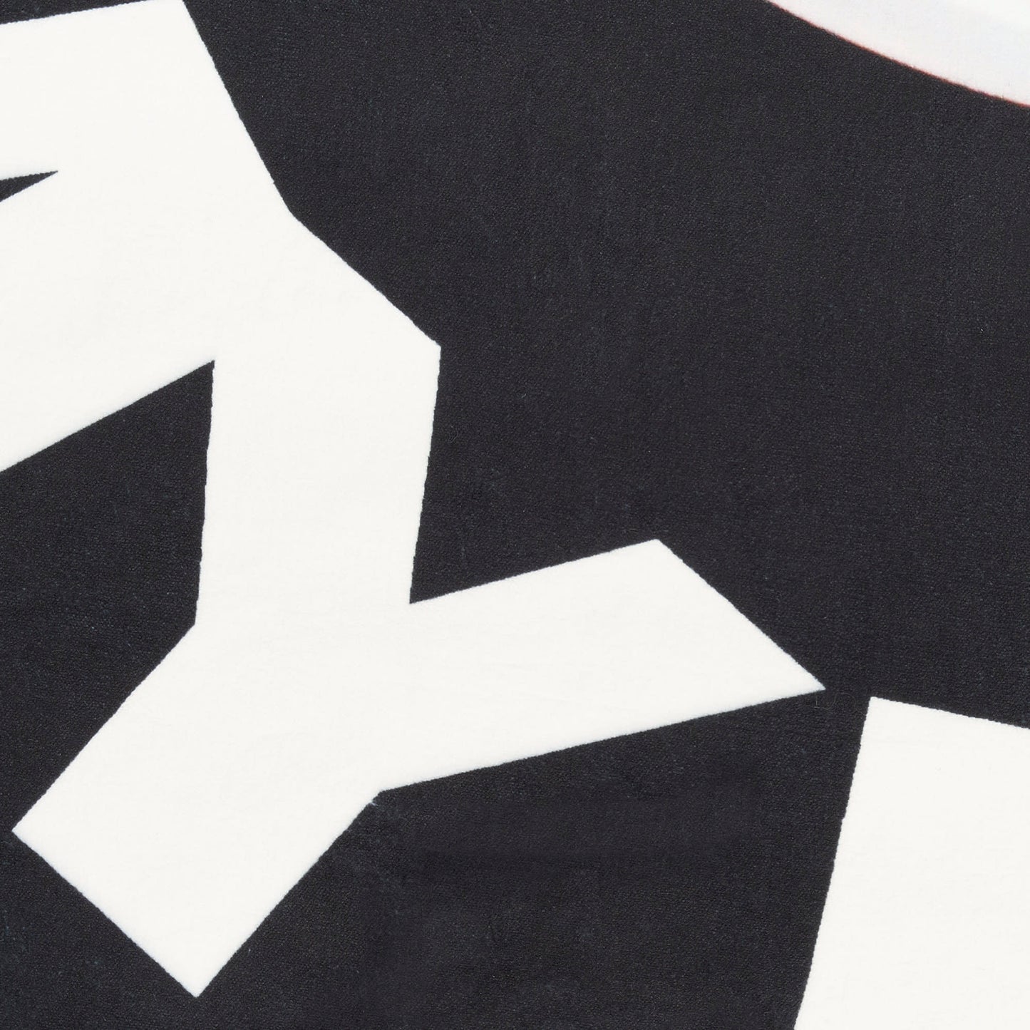 Close-up of a round black rug with large white angular geometric shapes for a bold modern abstract look.
