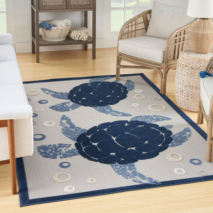 Rectangular coastal area rug with two navy-blue sea turtles on a light beige background, navy border.