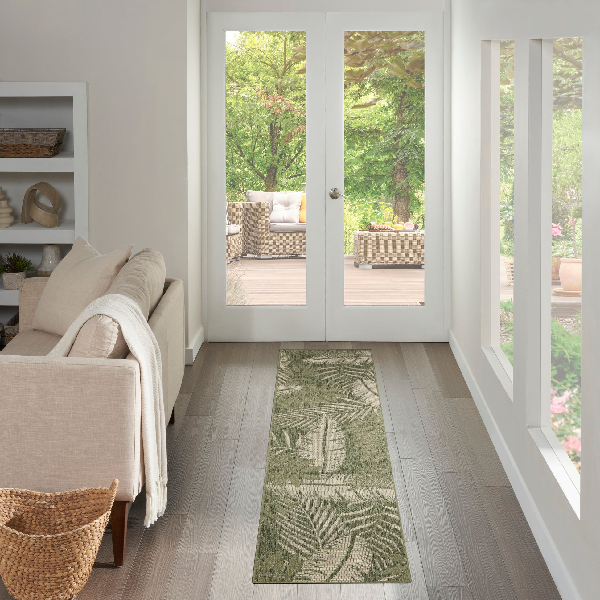 Long outdoor rectangular runner rug with a green palm-leaf pattern.