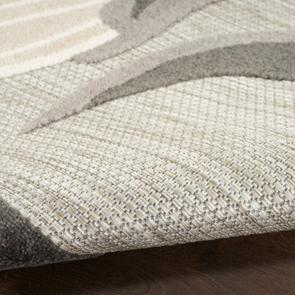 Close-up of a neutral beige-taupe woven area rug with an abstract curved motif on a dark wood floor.