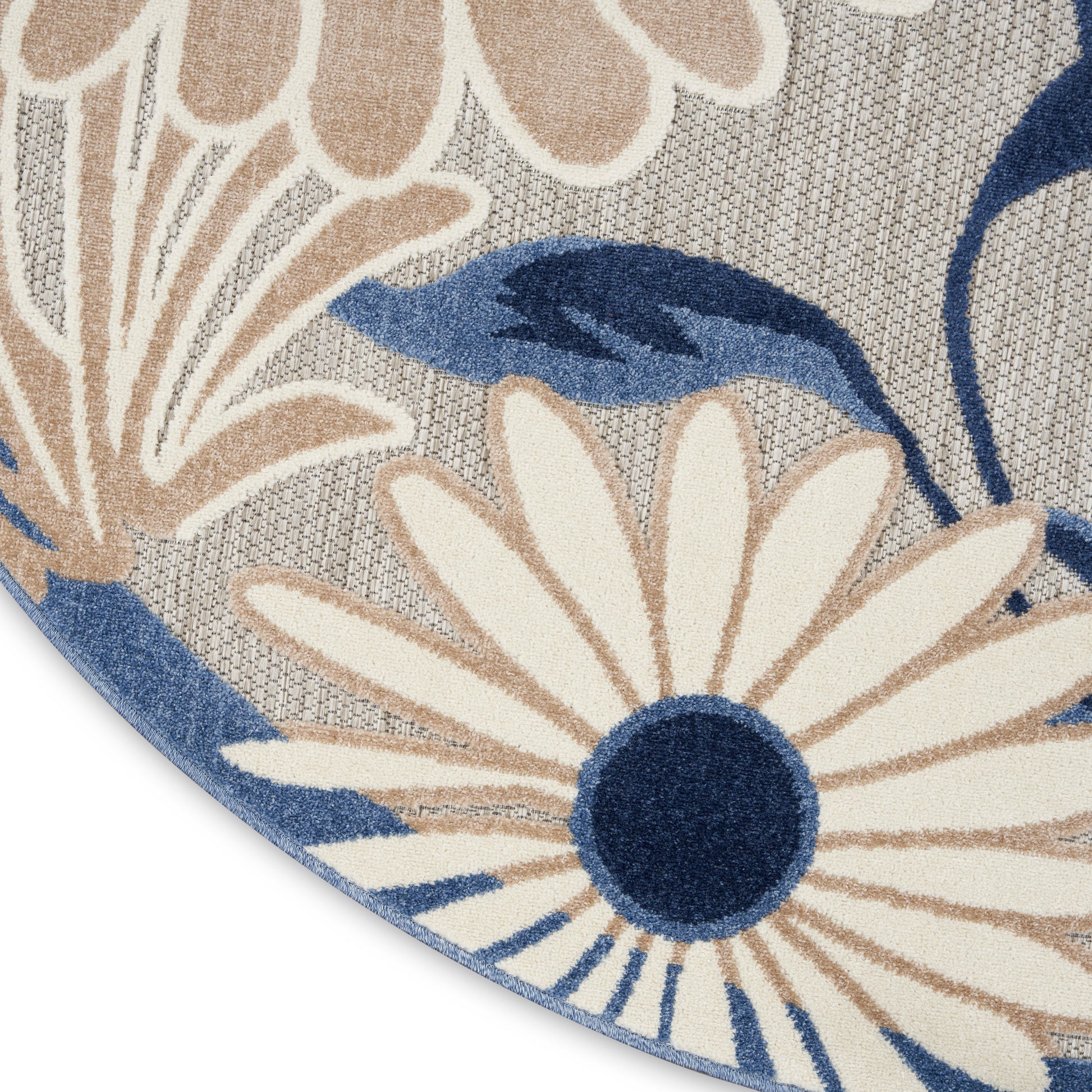 Round rug with daisy-like cream petals, navy centers and blue leaves on a textured gray woven backdrop.