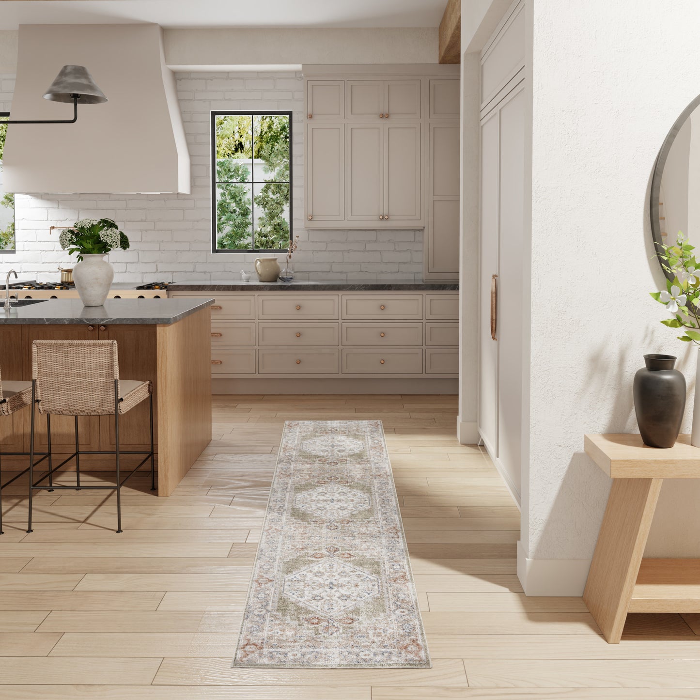 Beige kitchen with wooden island, gray countertop, woven stools, and pale runner rug.