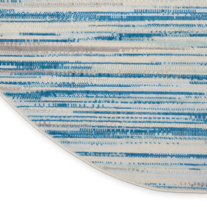 Round blue & cream striped rug with an abstract brushstroke pattern.