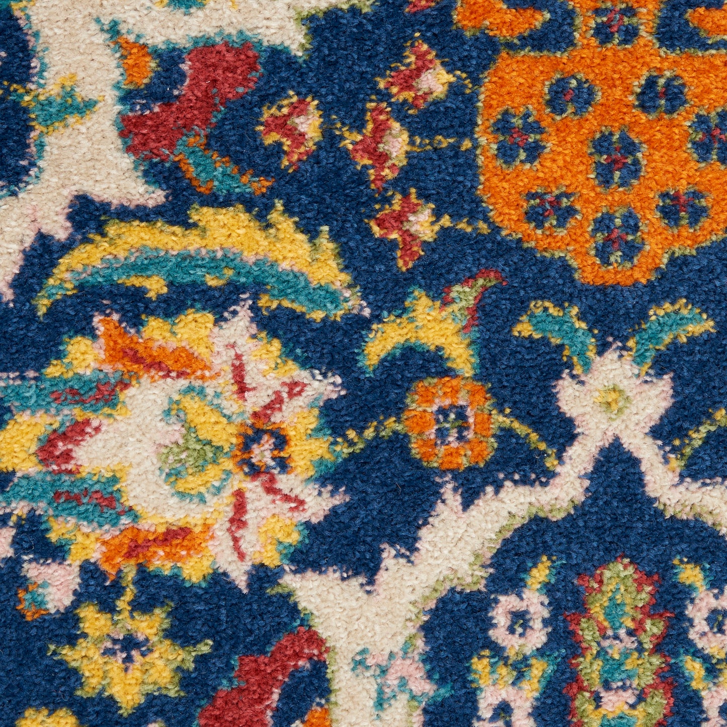 High-pile shag rug featuring a blue background with vibrant multicolor floral motifs in orange, yellow, white, teal and red.