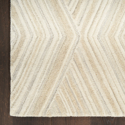 Beige and cream shag rug with chevron stripe pattern on dark wood floor.