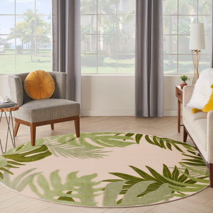 Round outdoor rug with a tropical green palm leaf pattern on beige.
