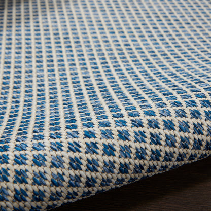 Blue and white woven rug runner with a geometric pattern and textured braided surface, 10 ft long.