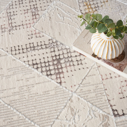 Beige patchwork woven rug with geometric motifs; ceramic ribbed vase with orange stripes and eucalyptus stems.