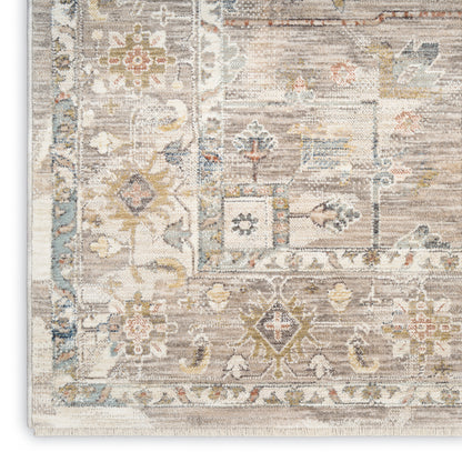 Rectangular distressed oriental area rug in ivory, beige and soft blue with gold accents; floral-geometric border.