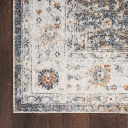 Ivory runner rug with blue floral motifs & decorative border on dark wooden floor.
