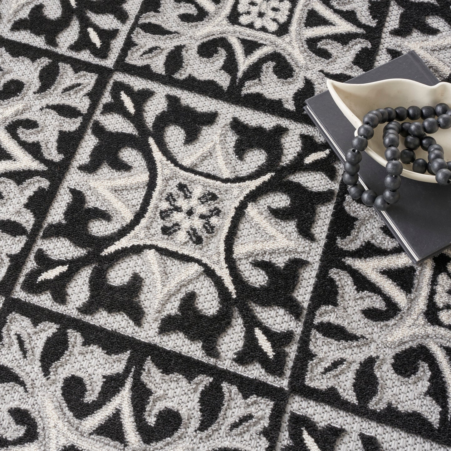 Gray and black ornate patterned round rug with tile motifs (8' round).