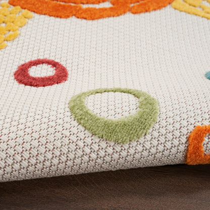 Cream woven area rug with multicolor circular tufted loops in green, red, orange, yellow; folded on wood floor.