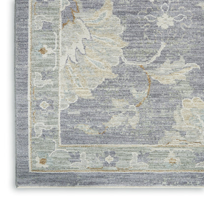 Muted blue-gray rug with cream and sage floral border, vintage damask pattern, soft textured pile.