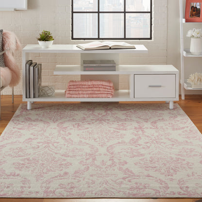 Vintage pink damask rug on wood floor, 6' x 9'.