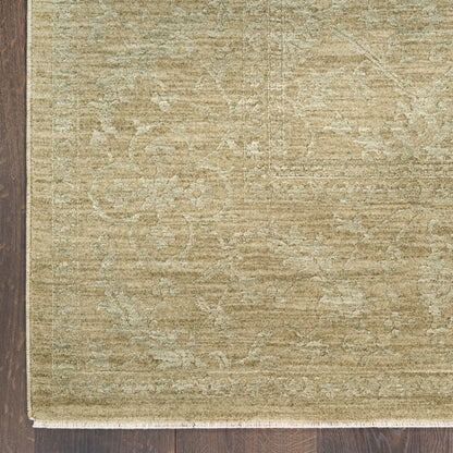 Beige vintage-style area rug with subtle floral motif and fringed edge on dark wood floor.