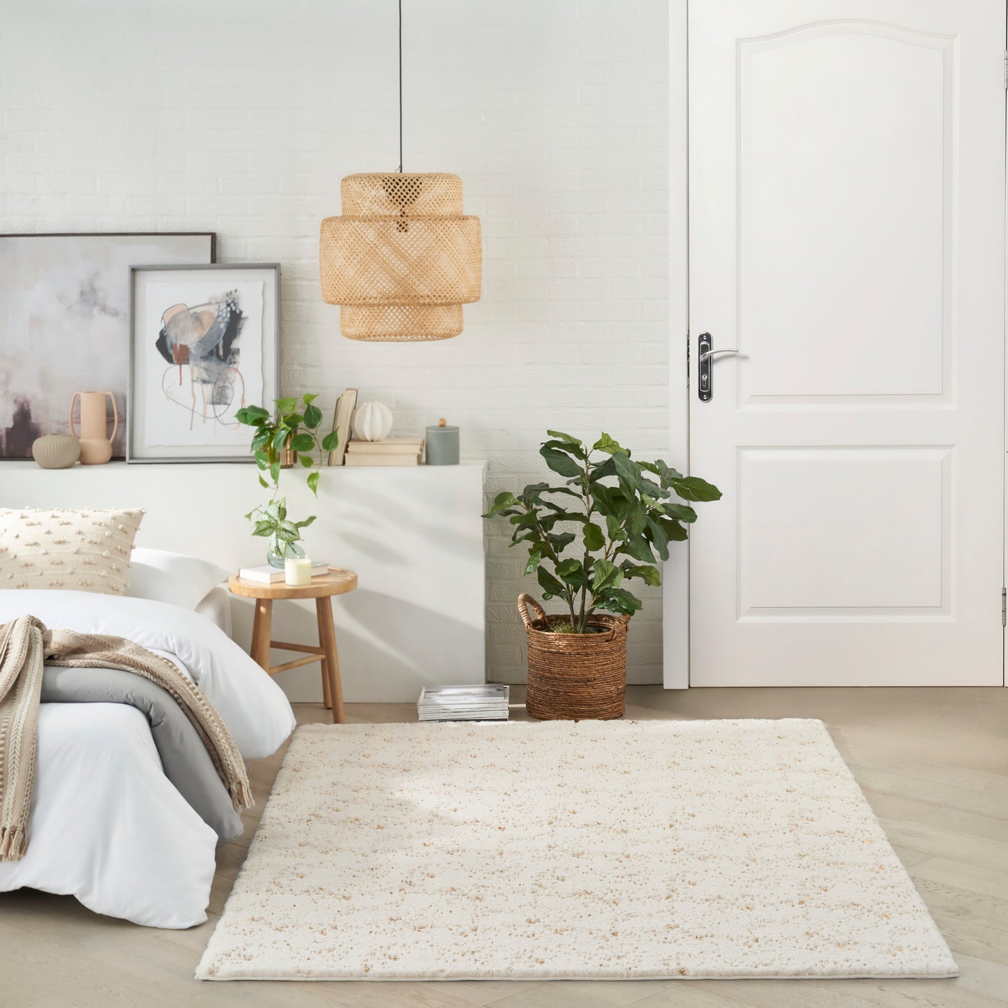 Cream shag rug in a bright minimalist bedroom with white walls, wicker pendant lamp, and green potted plant.