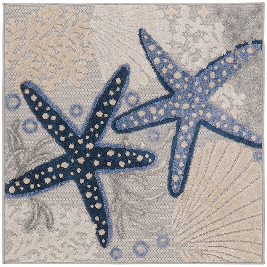 Rectangular coastal woven rug with two starfish in navy and sky blue on a beige coral and shell pattern.