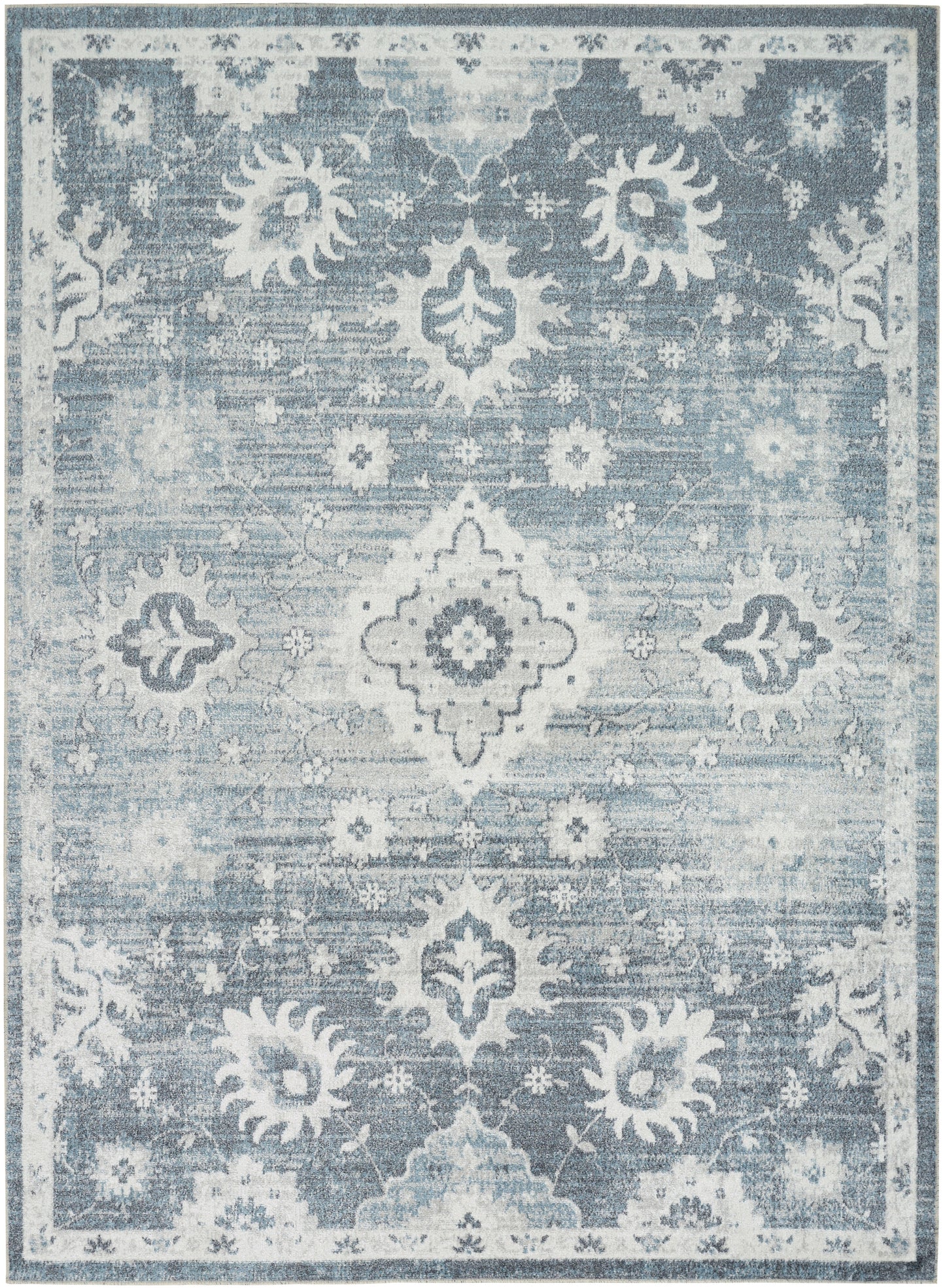Blue distressed area rug with white ornamental medallions, floral motifs, and a decorative border.