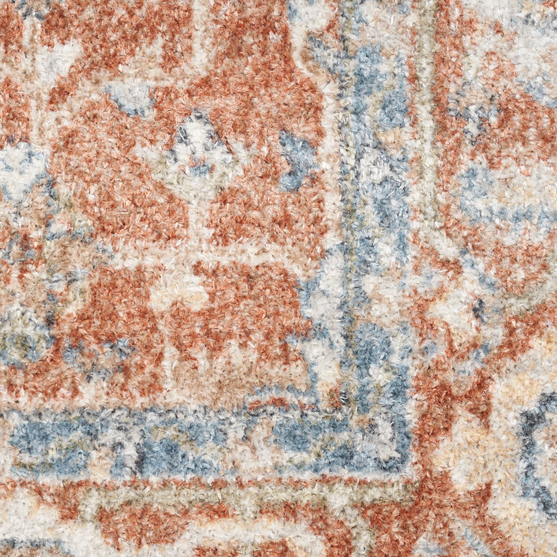 Close-up of a plush oriental rug with orange, blue & cream tones and a bordered vintage floral pattern.