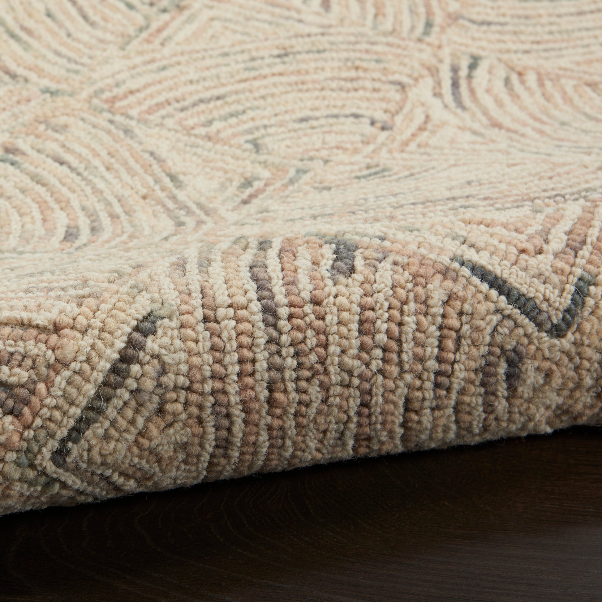 Beige geometric runner rug with plush loop pile in cream & tan & gray tones; close-up of folded corner.