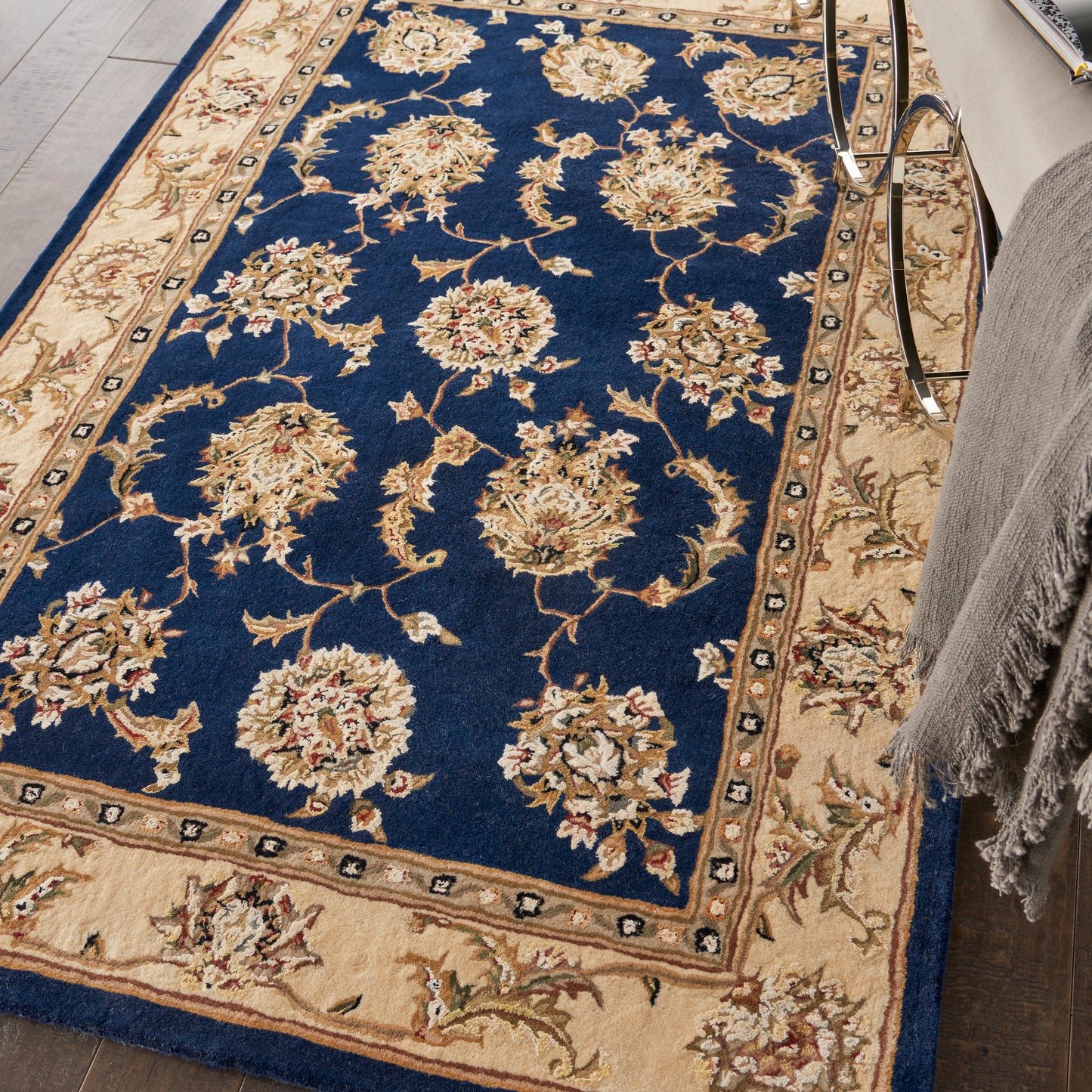 Persian-style rectangular rug with navy blue center, cream-beige floral motifs, beige border with small florals; plush pile.