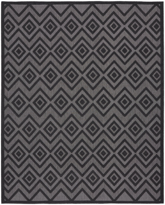 Geometric area rug with charcoal and gray diamond motifs and chevrons, bold repeating pattern.