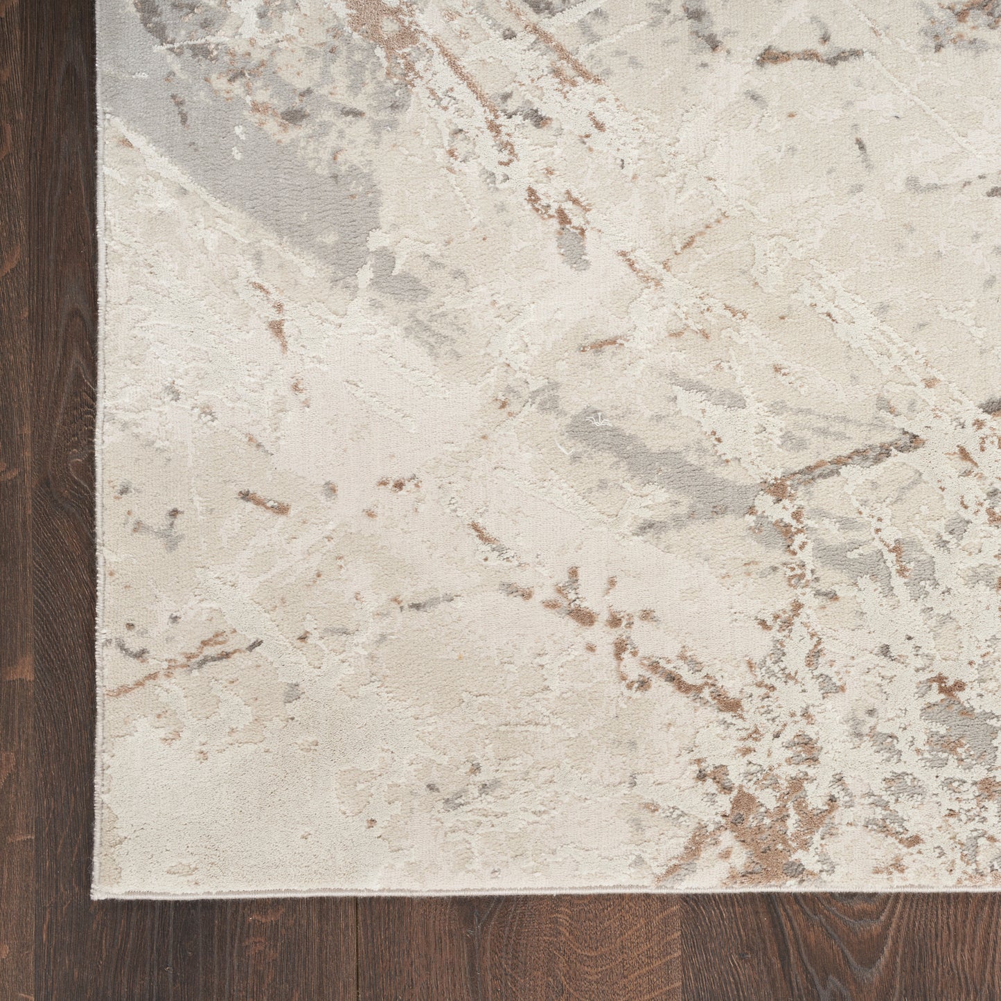 Rectangular beige abstract area rug with gray & taupe veining on dark wood floor.