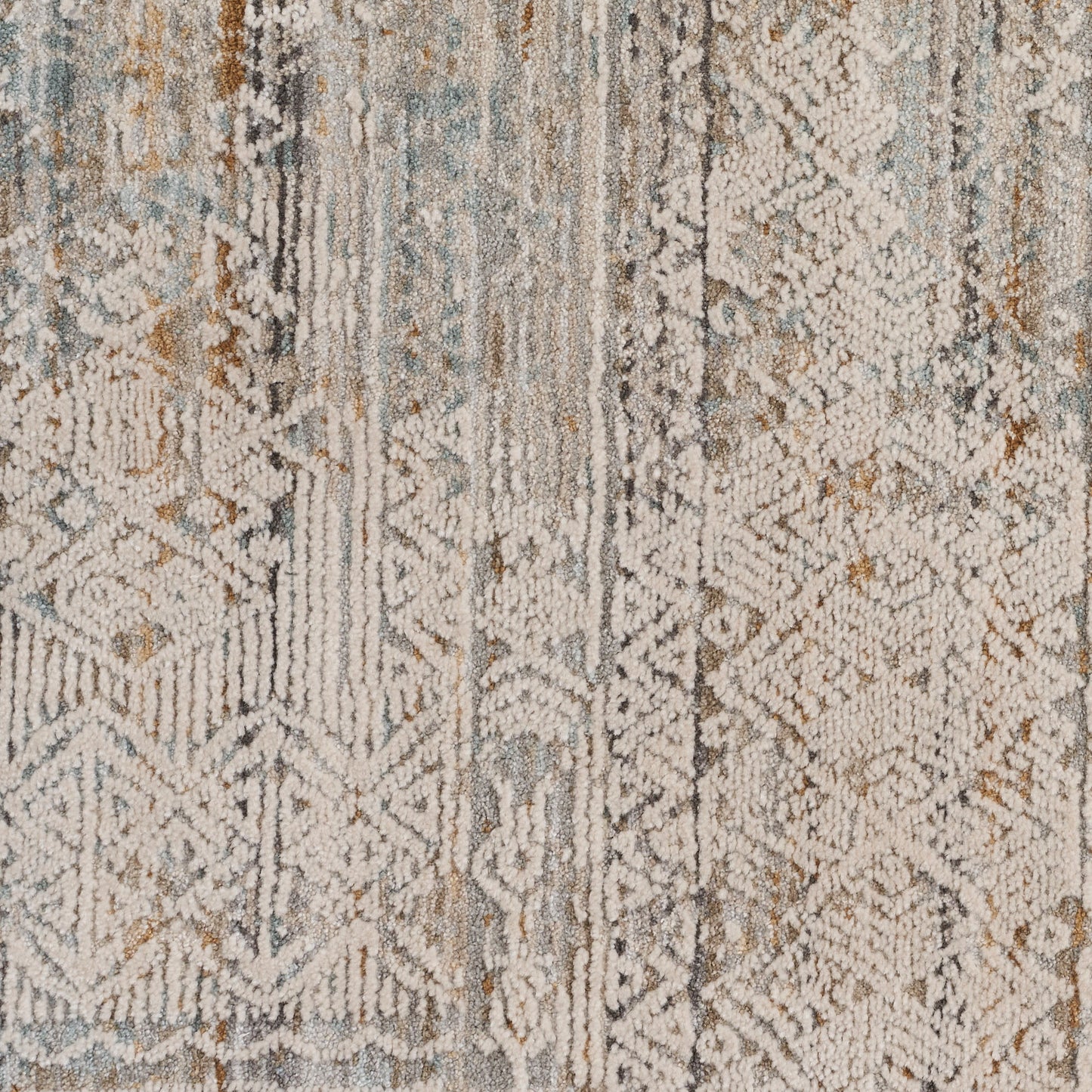 Distressed geometric area rug in muted blues, grays, and beiges with a textured pile.