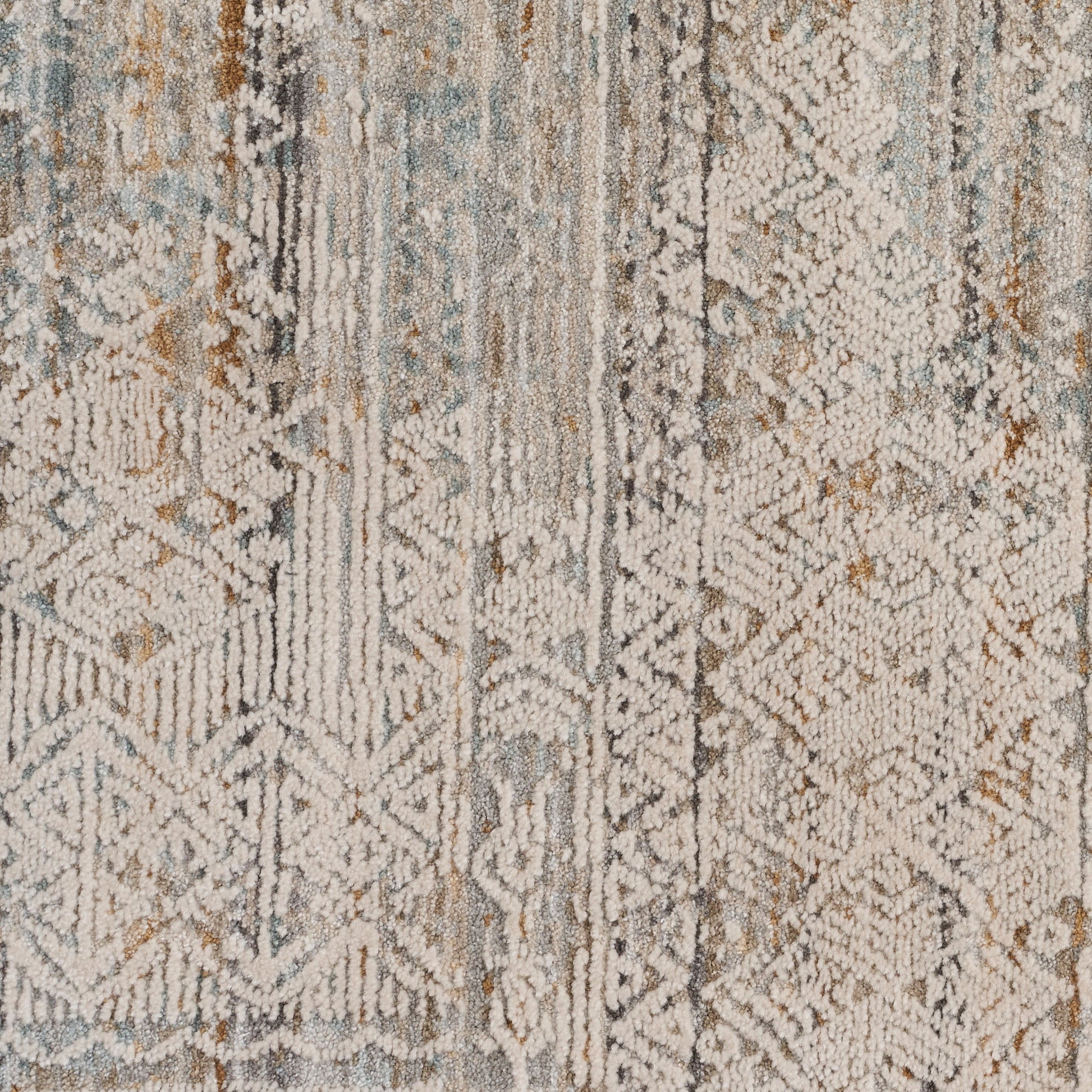 Distressed geometric area rug in muted blues, grays, and beiges with a textured pile.