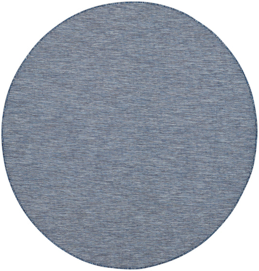 Round denim-blue woven rug with subtle grid texture and dark edge.