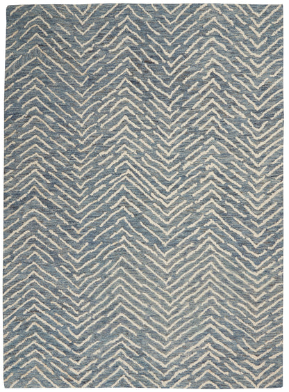 Blue rug with white zigzag chevron pattern; rectangular, woven texture, modern casual decor.