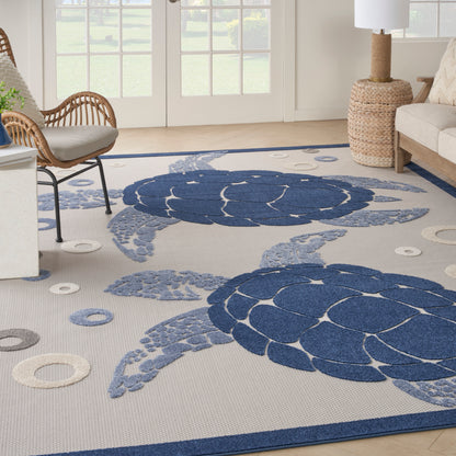 Coastal woven rug with large blue sea turtle motifs and circular accents on light beige background.