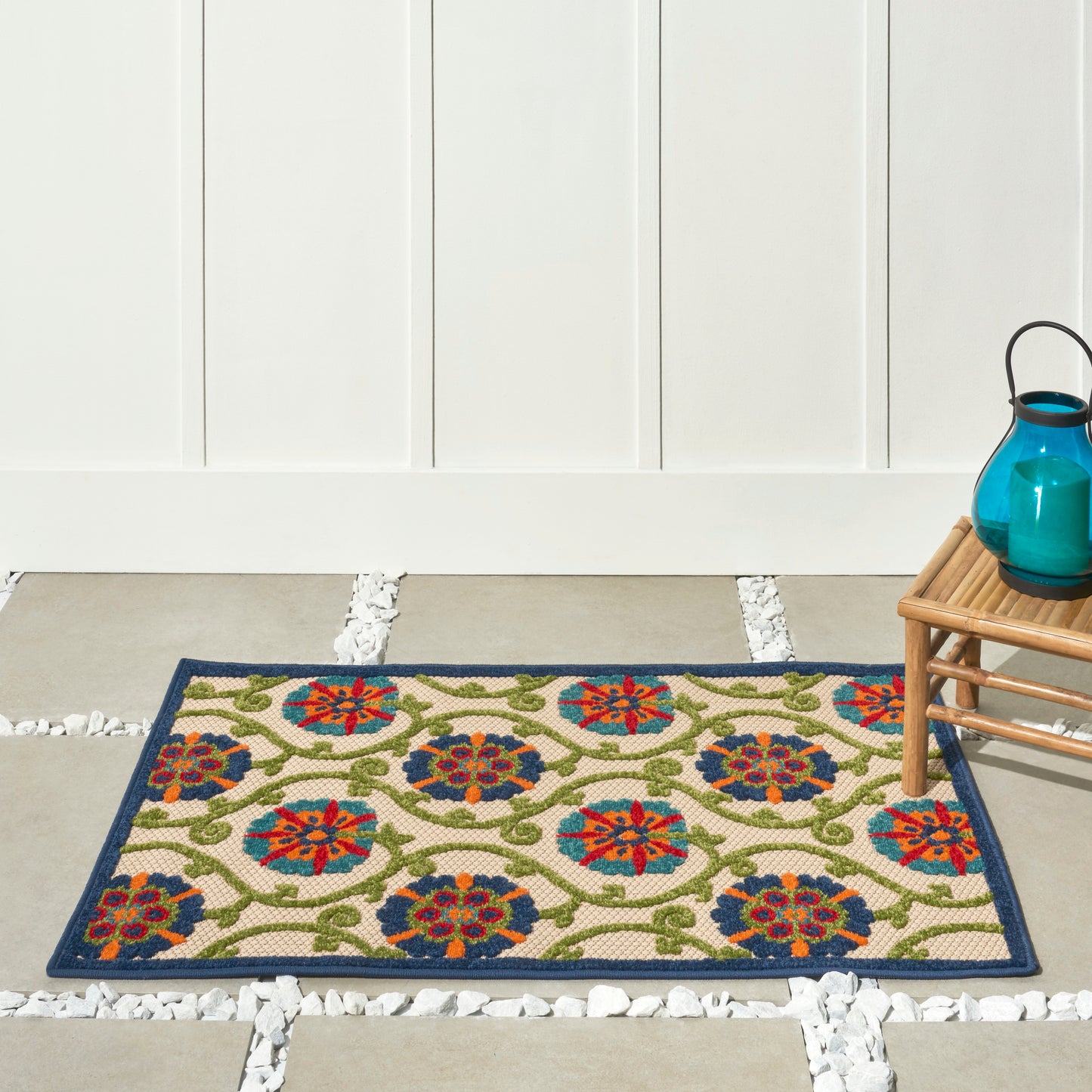 Woven beige rug with colorful circular floral medallions and a dark blue border.