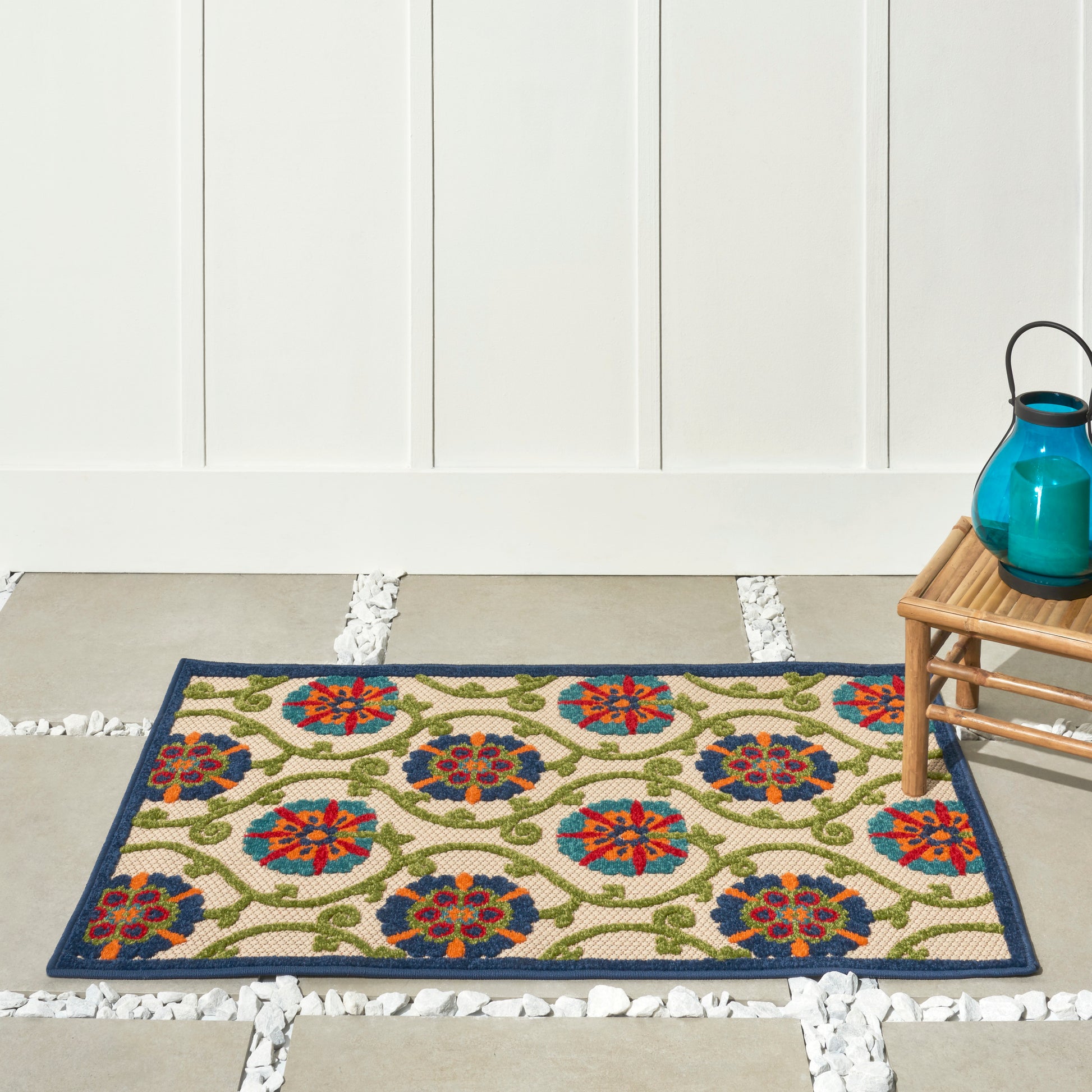 Woven beige rug with colorful circular floral medallions and a dark blue border.