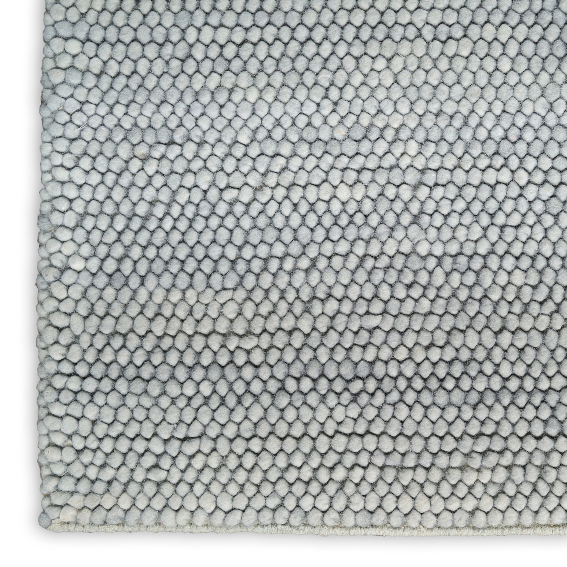 Close-up of a light gray loop-pile rug with tiny circular tufted loops, soft textured surface