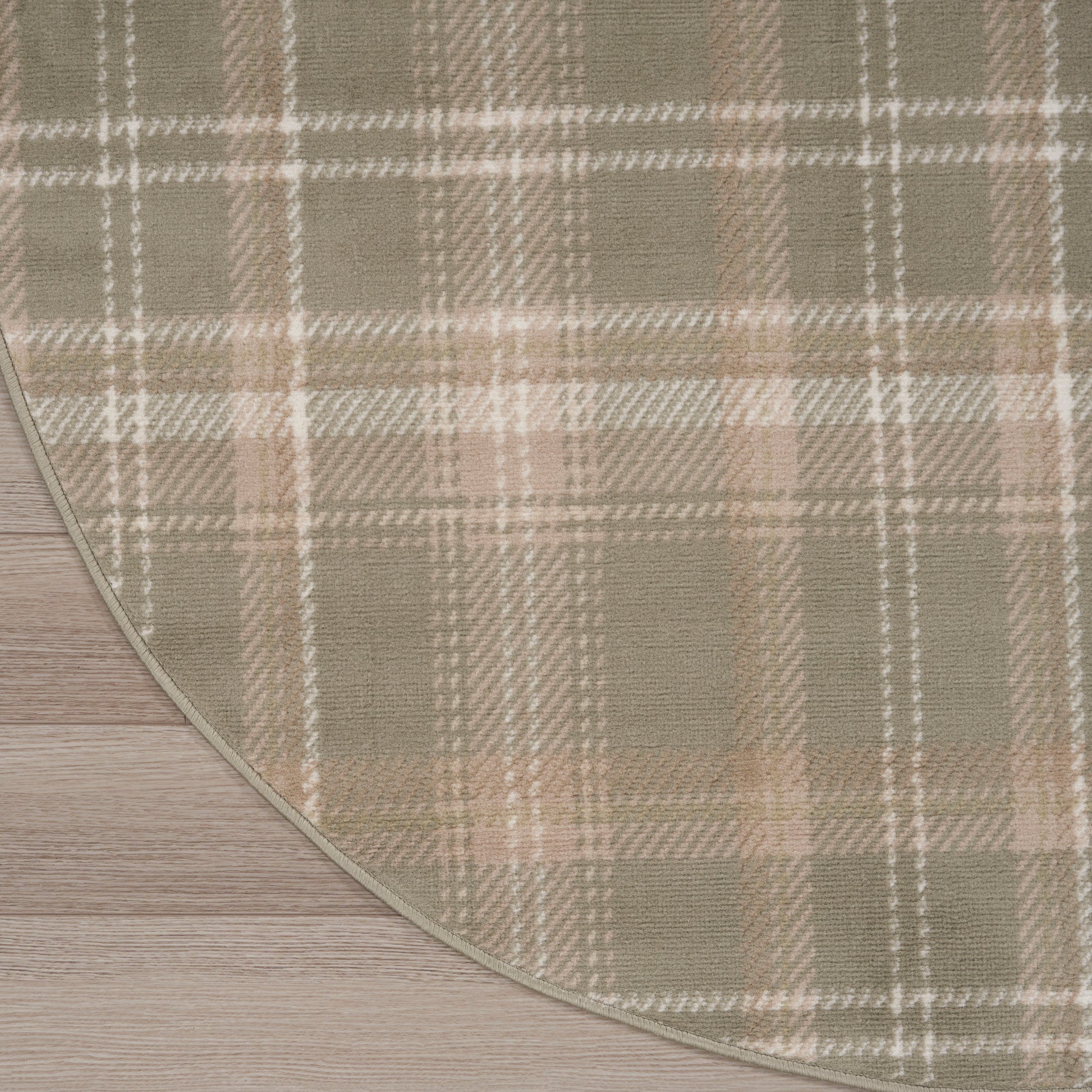 Beige plaid rug with taupe and white stripes, soft woven texture, curved edge on wood floor.