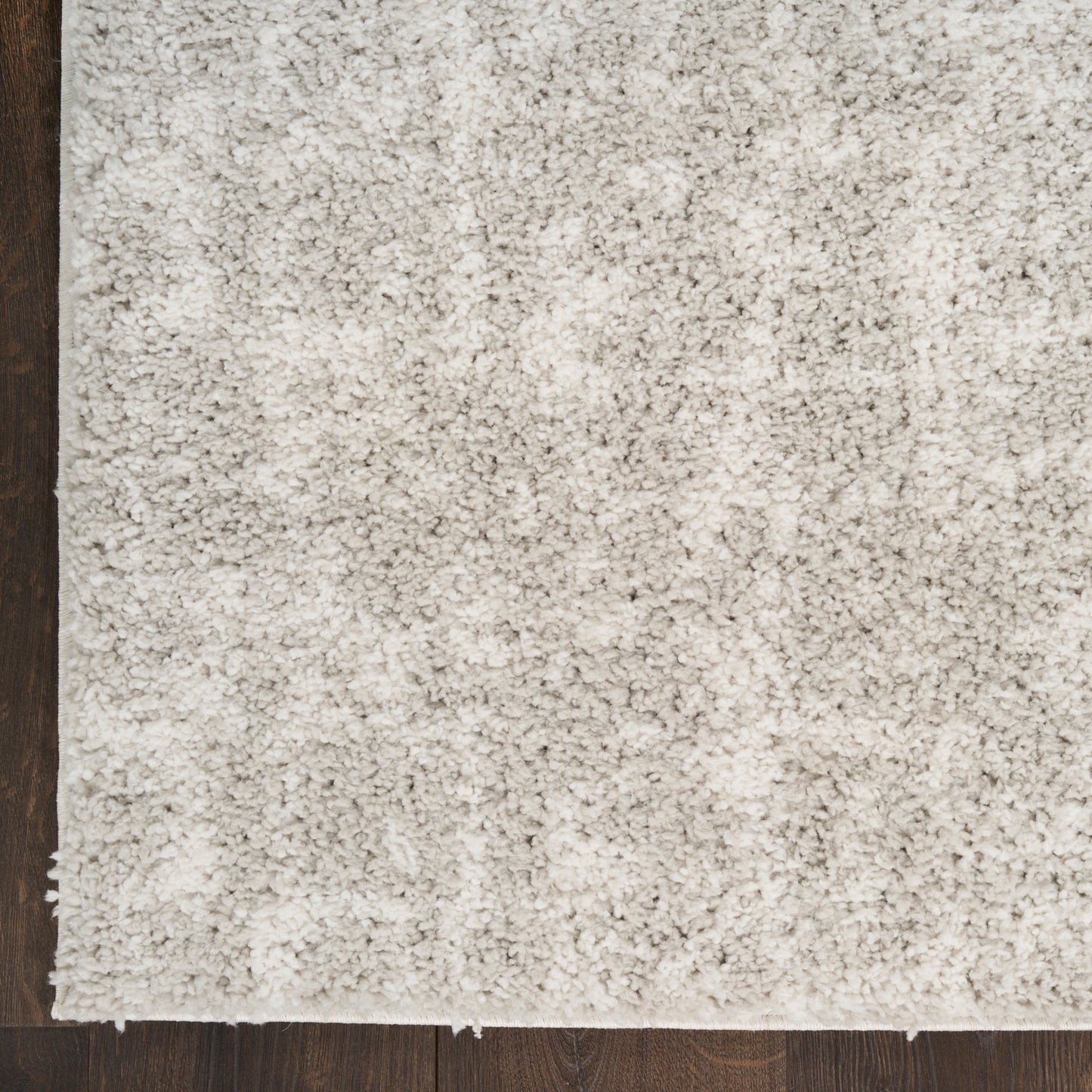 Beige cream shag rug with thick plush pile laid on dark wood flooring; cozy, modern style.
