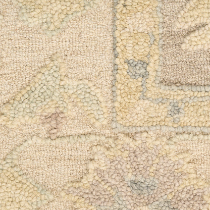 Cream-beige tufted rug with a subtle geometric motif in pale gray and yellow, chunky boucle pile.
