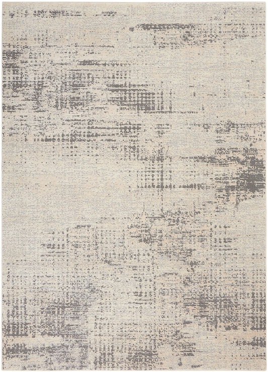 Beige abstract rug with gray distressed patches, neutral tones and soft texture.