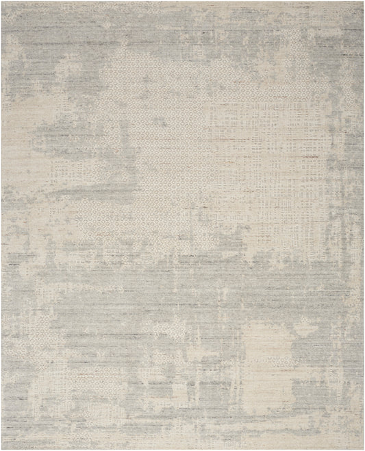 Light gray and beige abstract patchwork rug with muted distressed texture.