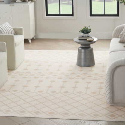 Cream geometric lattice area rug in a bright modern living room with white sofas and a gray metal side table.