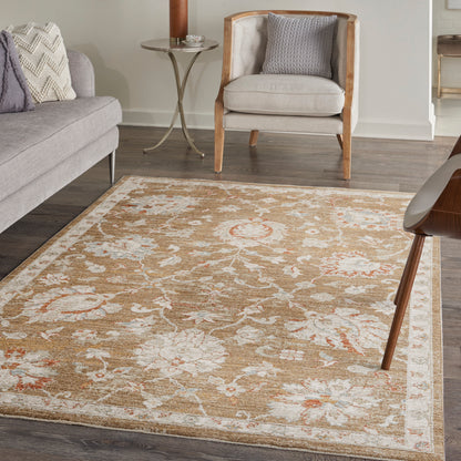 Beige-gold traditional area rug with ivory border and floral motifs in a cozy living room with gray sofa and light wood chairs.