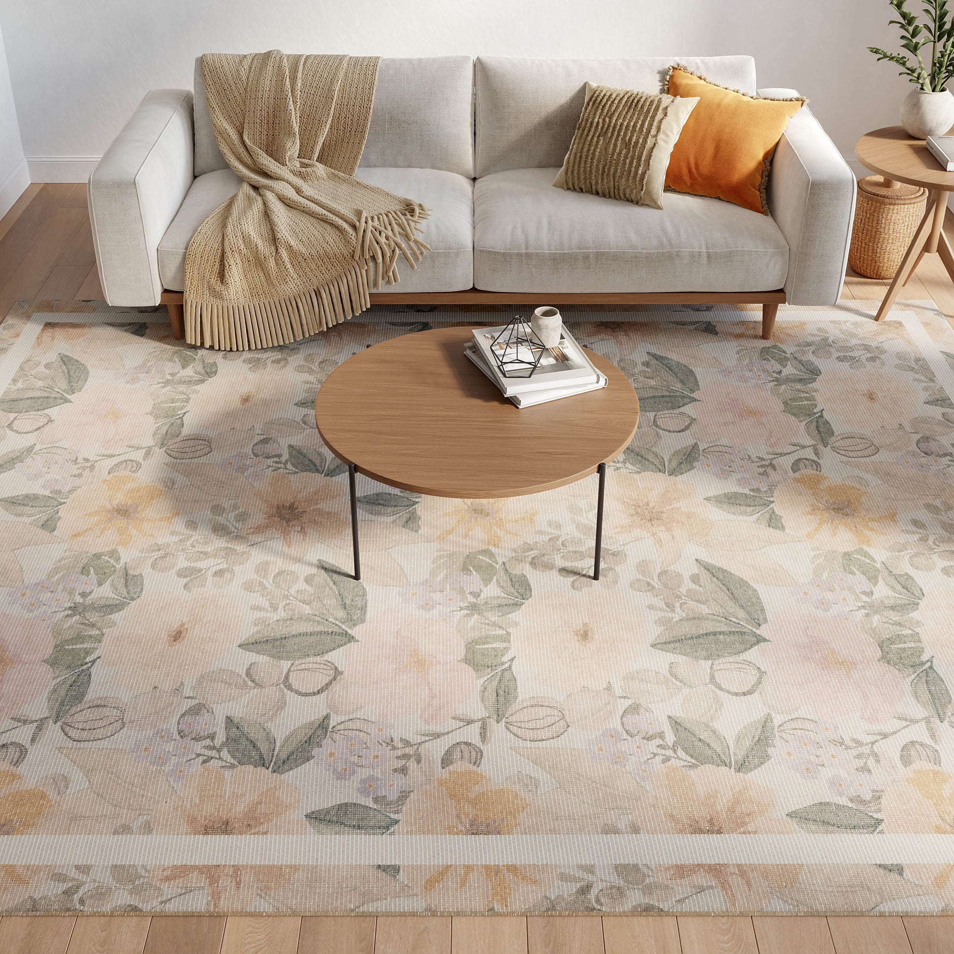 Cozy living room: beige sofa with tan throw and orange pillows, round wood coffee table, on a pastel floral rug.