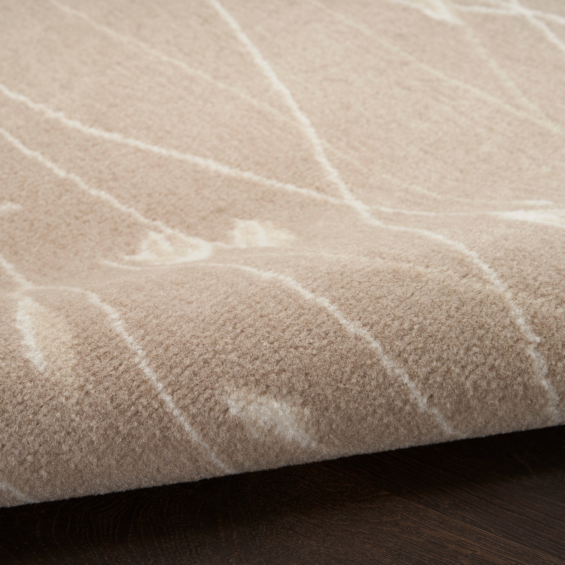 Beige plush runner rug with white linear stripes, soft thick pile on dark wood floor.