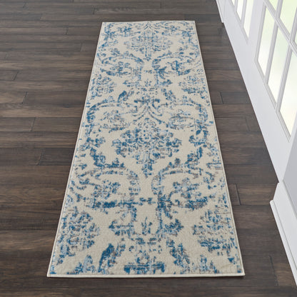 Beige and blue damask runner rug, long rectangular, on dark wood floor near white-framed windows.