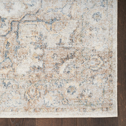 Distressed cream & blue oriental rug with tan accents, rectangular shape, classic floral motifs, on dark hardwood.