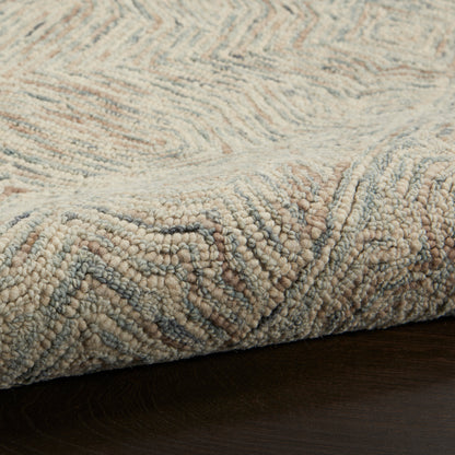 Beige cream loop-pile rug with light blue accents and subtle chevron pattern on dark wood floor.