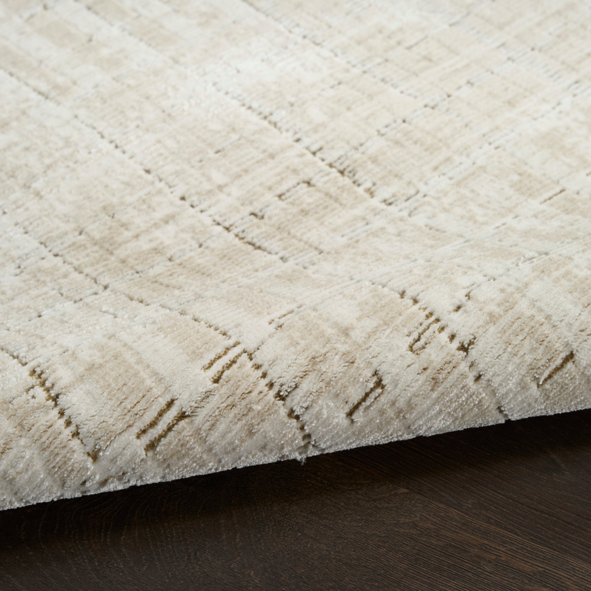Beige textured rug with a subtle geometric pattern on dark wood floor