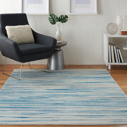Blue and white striped area rug in a modern living room with a black armchair, white brick wall, plant, and minimalist shelf.